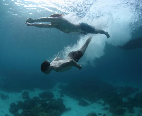 Two men gliding in a sea after jump — Stock Photo, Image