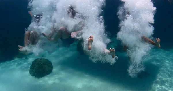 Grupo de amigos pulando no mar — Fotografia de Stock