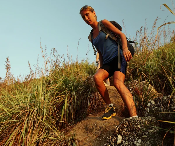 Escursionista con zaino a piedi attraverso un terreno roccioso — Foto Stock