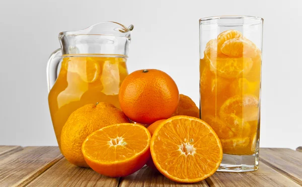 Апельсиновый сок в стекле и ломтиках — стоковое фото