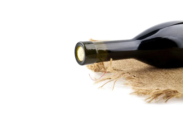 Bottle of wine on rough material — Stock Photo, Image