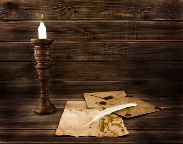 Feather, old paper and candle — Stock Photo, Image