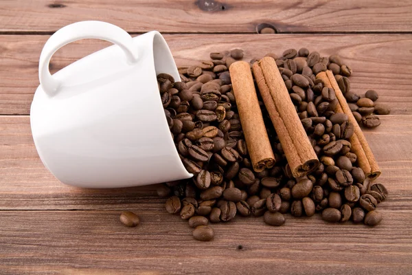 Зерна кофе и чашки — стоковое фото