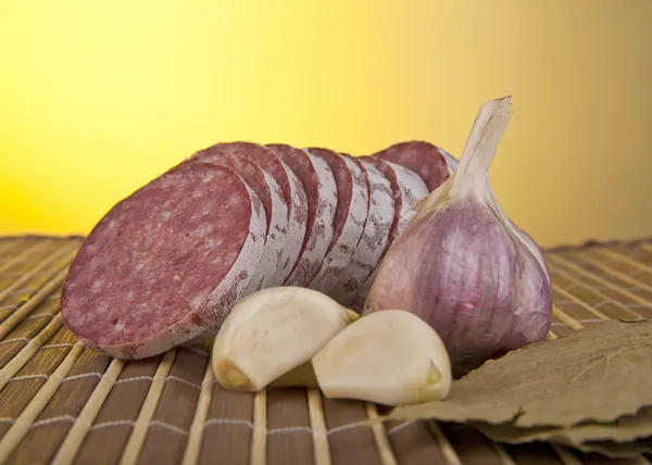 Salame with garlic and laurel leaves — Stock Photo, Image