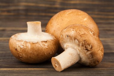 Ahşap arka planda mantarlar. Tahta bir masada şampiyon mantarları. Tasarım ayrıntıları. Tasarım elemanları. Makro. Tam odaklanma. Kartvizitler, kartpostallar ve posterler için arka plan 