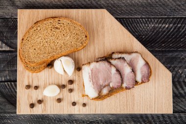 Domuz yağlı sarımsaklı ekmek ve ahşap bir arka planda baharat. Tasarım ayrıntıları. Tasarım elemanları. Makro. Tam odaklanma. Kartvizitler, kartpostallar ve posterler için arka plan