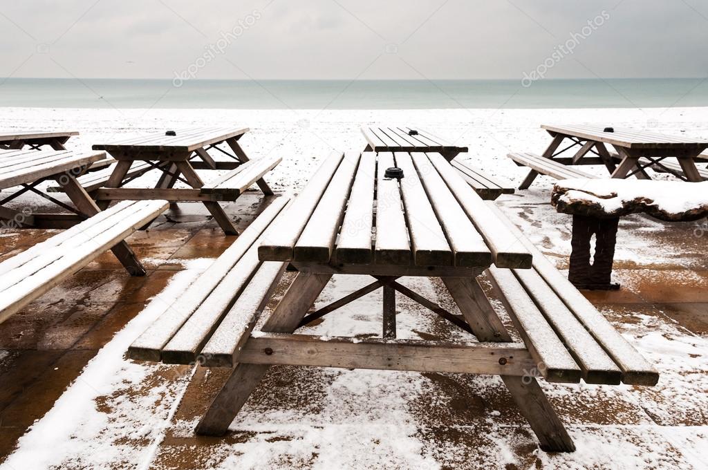 Wooden tables covered by snow