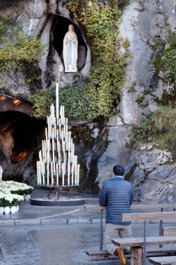 Mağara, pınar, Lourdes Bazilikası ve mumlar.