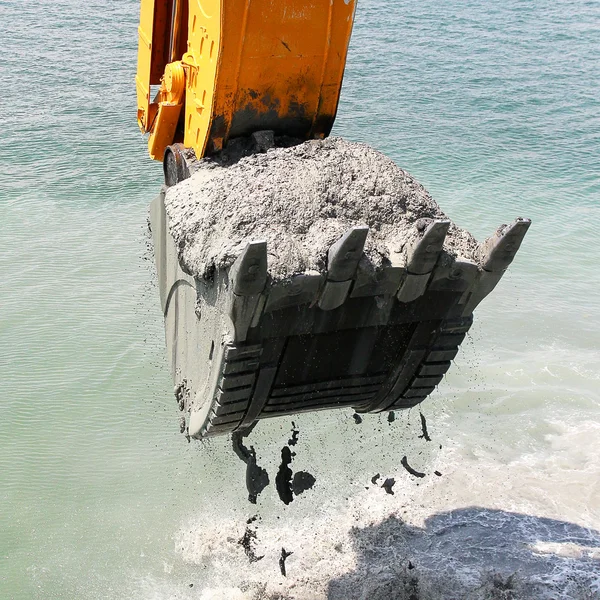 Balde de escavadeira de água pega o solo do fundo do mar — Fotografia de Stock