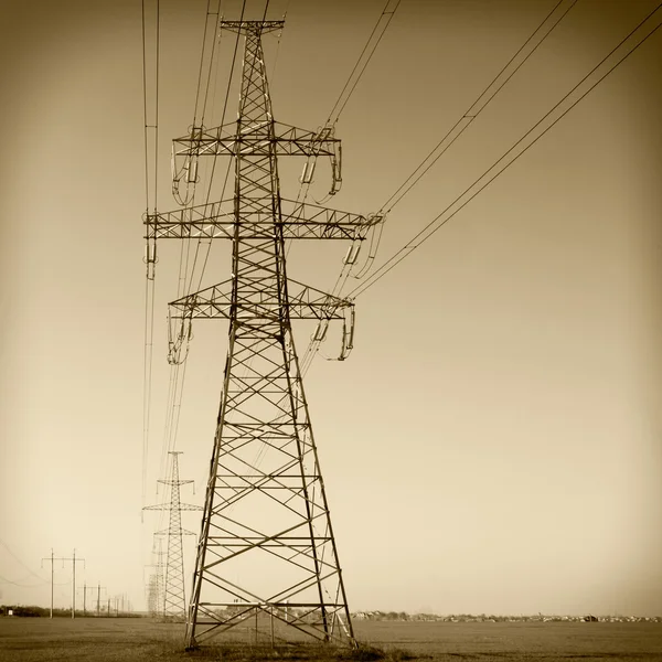 Energii elektrycznej pylon przeciw błękitne niebo pochmurne. Vintage — Zdjęcie stockowe