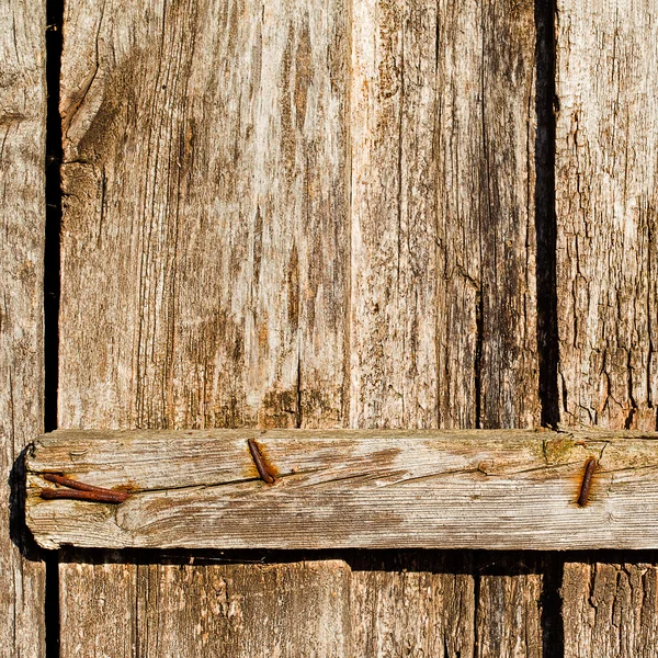 Old used and rusty iron nails on a wooden door — Stock Photo, Image