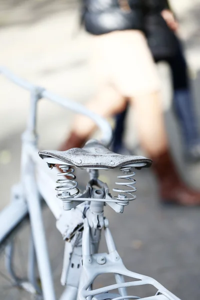 Detail of a Vintage Bicycle Saddle with a beautiful bokeh. Pedestrians on the street — Stock Photo, Image