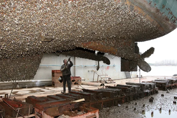 Ouvrier du chantier naval nettoie le navire stuya eau — Photo