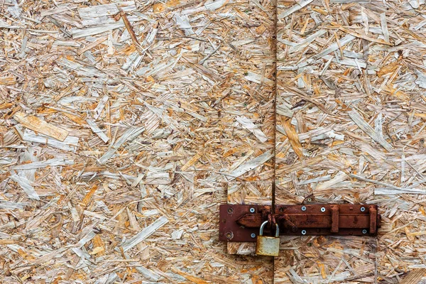 Kunci logam pada latar belakang abstrak terkompresi chippings kayu b — Stok Foto
