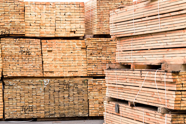 A pile of wood edged boards packed in stacks with tags size para
