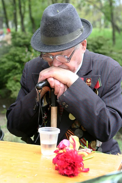 Elderly veteran of the Victory Day over a glass of vodka recalls — Stock Photo, Image