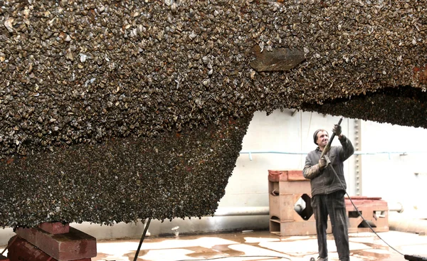 Travail en cale sèche avec jet d'eau nettoie le fond du navire en — Photo