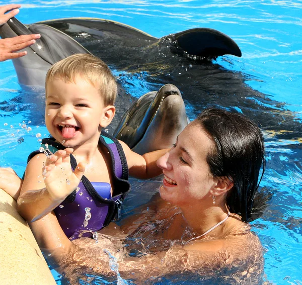 Happy beautiful young woman with a small child laughs and swims — Stock Photo, Image