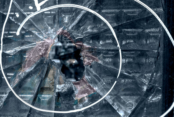 Broken window with a bullet hole in the middle