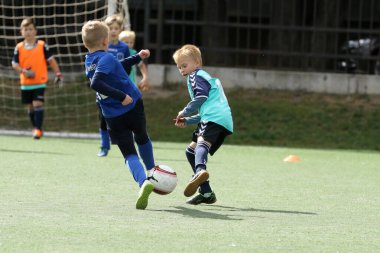 ODESSA, UKRAINE - 25 Eylül 2021: Küçük çocuklar, küçük çocuklar spor şampiyonası kasabasında yapay sahada futbol oynuyorlar. Çocuk sporları sağlıklı yaşam tarzıdır. Spor çocukları futbol oyuncuları