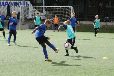 ODESSA, UKRAINE - 25 Eylül 2021: Küçük çocuklar, küçük çocuklar spor şampiyonası kasabasında yapay sahada futbol oynuyorlar. Çocuk sporları sağlıklı yaşam tarzıdır. Spor çocukları futbol oyuncuları