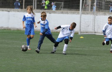 ODESSA, UKRAINE - 25 Eylül 2021: Küçük çocuklar, küçük çocuklar spor şampiyonası kasabasında yapay sahada futbol oynuyorlar. Çocuk sporları sağlıklı yaşam tarzıdır. Spor çocukları futbol oyuncuları