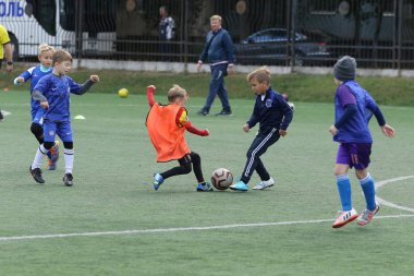 ODESSA, UKRAINE - 25 Eylül 2021: Küçük çocuklar, küçük çocuklar spor şampiyonası kasabasında yapay sahada futbol oynuyorlar. Çocuk sporları sağlıklı yaşam tarzıdır. Spor çocukları futbol oyuncuları