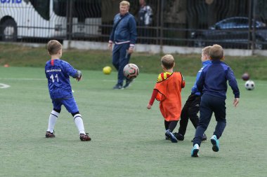 ODESSA, UKRAINE - 25 Eylül 2021: Küçük çocuklar, küçük çocuklar spor şampiyonası kasabasında yapay sahada futbol oynuyorlar. Çocuk sporları sağlıklı yaşam tarzıdır. Spor çocukları futbol oyuncuları