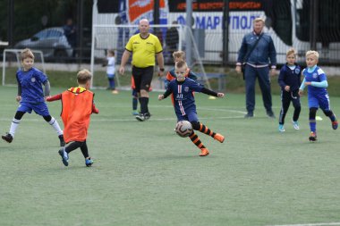 ODESSA, UKRAINE - 25 Eylül 2021: Küçük çocuklar, küçük çocuklar spor şampiyonası kasabasında yapay sahada futbol oynuyorlar. Çocuk sporları sağlıklı yaşam tarzıdır. Spor çocukları futbol oyuncuları