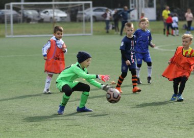 ODESSA, UKRAINE - 25 Eylül 2021: Küçük çocuklar, küçük çocuklar spor şampiyonası kasabasında yapay sahada futbol oynuyorlar. Çocuk sporları sağlıklı yaşam tarzıdır. Spor çocukları futbol oyuncuları