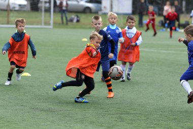 ODESSA, UKRAINE - 25 Eylül 2021: Küçük çocuklar, küçük çocuklar spor şampiyonası kasabasında yapay sahada futbol oynuyorlar. Çocuk sporları sağlıklı yaşam tarzıdır. Spor çocukları futbol oyuncuları