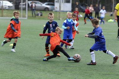 ODESSA, UKRAINE - 25 Eylül 2021: Küçük çocuklar, küçük çocuklar spor şampiyonası kasabasında yapay sahada futbol oynuyorlar. Çocuk sporları sağlıklı yaşam tarzıdır. Spor çocukları futbol oyuncuları