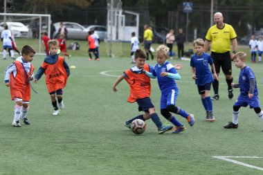 ODESSA, UKRAINE - 25 Eylül 2021: Küçük çocuklar, küçük çocuklar spor şampiyonası kasabasında yapay sahada futbol oynuyorlar. Çocuk sporları sağlıklı yaşam tarzıdır. Spor çocukları futbol oyuncuları