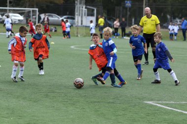 ODESSA, UKRAINE - 25 Eylül 2021: Küçük çocuklar, küçük çocuklar spor şampiyonası kasabasında yapay sahada futbol oynuyorlar. Çocuk sporları sağlıklı yaşam tarzıdır. Spor çocukları futbol oyuncuları