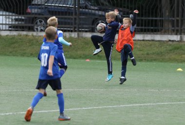 ODESSA, UKRAINE - 25 Eylül 2021: Küçük çocuklar, küçük çocuklar spor şampiyonası kasabasında yapay sahada futbol oynuyorlar. Çocuk sporları sağlıklı yaşam tarzıdır. Spor çocukları futbol oyuncuları