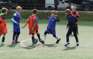 ODESSA, UKRAINE - 25 Eylül 2021: Küçük çocuklar, küçük çocuklar spor şampiyonası kasabasında yapay sahada futbol oynuyorlar. Çocuk sporları sağlıklı yaşam tarzıdır. Spor çocukları futbol oyuncuları