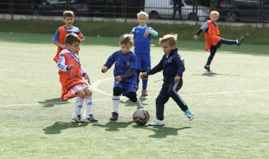 ODESSA, UKRAINE - 25 Eylül 2021: Küçük çocuklar, küçük çocuklar spor şampiyonası kasabasında yapay sahada futbol oynuyorlar. Çocuk sporları sağlıklı yaşam tarzıdır. Spor çocukları futbol oyuncuları