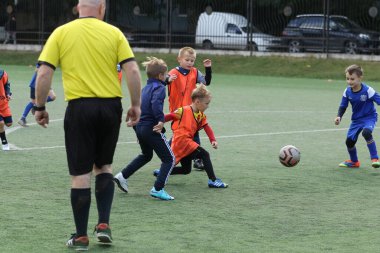ODESSA, UKRAINE - 25 Eylül 2021: Küçük çocuklar, küçük çocuklar spor şampiyonası kasabasında yapay sahada futbol oynuyorlar. Çocuk sporları sağlıklı yaşam tarzıdır. Spor çocukları futbol oyuncuları