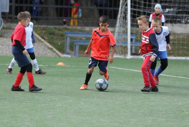 ODESSA, UKRAINE - 25 Eylül 2021: Küçük çocuklar, küçük çocuklar spor şampiyonası kasabasında yapay sahada futbol oynuyorlar. Çocuk sporları sağlıklı yaşam tarzıdır. Spor çocukları futbol oyuncuları