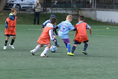 ODESSA, UKRAINE - 25 Eylül 2021: Küçük çocuklar, küçük çocuklar spor şampiyonası kasabasında yapay sahada futbol oynuyorlar. Çocuk sporları sağlıklı yaşam tarzıdır. Spor çocukları futbol oyuncuları