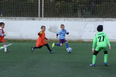 ODESSA, UKRAINE - 25 Eylül 2021: Küçük çocuklar, küçük çocuklar spor şampiyonası kasabasında yapay sahada futbol oynuyorlar. Çocuk sporları sağlıklı yaşam tarzıdır. Spor çocukları futbol oyuncuları