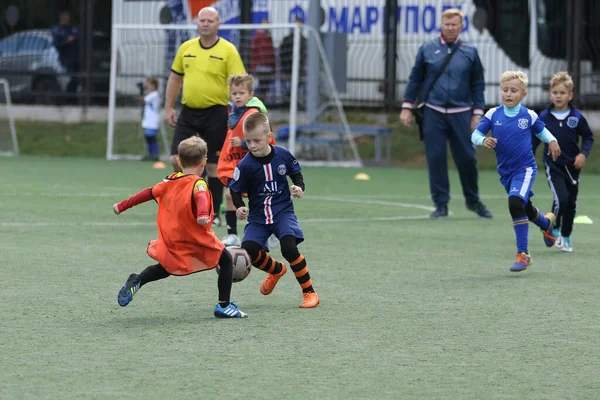 ODESSA, UKRAINE - 25 Eylül 2021: Küçük çocuklar, küçük çocuklar spor şampiyonası kasabasında yapay sahada futbol oynuyorlar. Çocuk sporları sağlıklı yaşam tarzıdır. Spor çocukları futbol oyuncuları