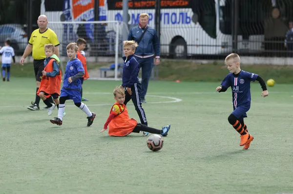 ODESSA, UKRAINE - 25 Eylül 2021: Küçük çocuklar, küçük çocuklar spor şampiyonası kasabasında yapay sahada futbol oynuyorlar. Çocuk sporları sağlıklı yaşam tarzıdır. Spor çocukları futbol oyuncuları