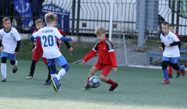 ODESSA, UKRAINE - 25 Eylül 2021: Küçük çocuklar, küçük çocuklar spor şampiyonası kasabasında yapay sahada futbol oynuyorlar. Çocuk sporları sağlıklı yaşam tarzıdır. Spor çocukları futbol oyuncuları