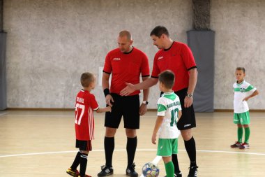 ODESSA, UKRAINE - 14 Ekim 2021: Küçük çocuklar 8-9 yaşlarında, Ukrayna Şampiyonası 'nda spor salonunda mini futbol oynuyorlar. Çocuk sporları sağlıklı yaşam tarzıdır. Erkek sporcular futsal yapıyor.