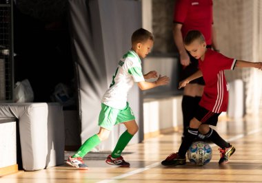 ODESSA, UKRAINE - 14 Ekim 2021: Küçük çocuklar 8-9 yaşlarında, Ukrayna Şampiyonası 'nda spor salonunda mini futbol oynuyorlar. Çocuk sporları sağlıklı yaşam tarzıdır. Erkek sporcular futsal yapıyor.