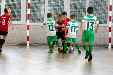 ODESSA, UKRAINE - 14 Ekim 2021: Küçük çocuklar 8-9 yaşlarında, Ukrayna Şampiyonası 'nda spor salonunda mini futbol oynuyorlar. Çocuk sporları sağlıklı yaşam tarzıdır. Erkek sporcular futsal yapıyor.
