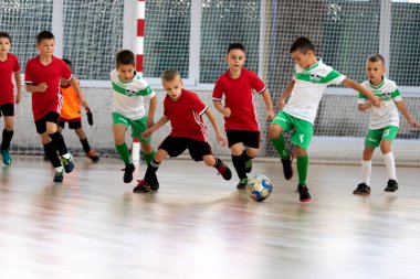 ODESSA, UKRAINE - 14 Ekim 2021: Küçük çocuklar 8-9 yaşlarında, Ukrayna Şampiyonası 'nda spor salonunda mini futbol oynuyorlar. Çocuk sporları sağlıklı yaşam tarzıdır. Erkek sporcular futsal yapıyor.