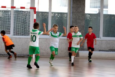 ODESSA, UKRAINE - 14 Ekim 2021: Küçük çocuklar 8-9 yaşlarında, Ukrayna Şampiyonası 'nda spor salonunda mini futbol oynuyorlar. Çocuk sporları sağlıklı yaşam tarzıdır. Erkek sporcular futsal yapıyor.