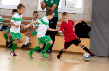 ODESSA, UKRAINE - 14 Ekim 2021: Küçük çocuklar 8-9 yaşlarında, Ukrayna Şampiyonası 'nda spor salonunda mini futbol oynuyorlar. Çocuk sporları sağlıklı yaşam tarzıdır. Erkek sporcular futsal yapıyor.